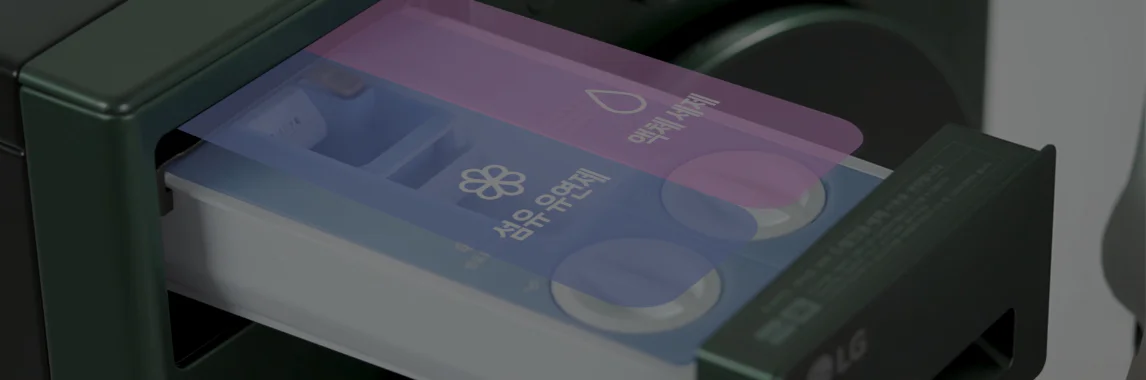 세탁기의 세제 투입구가 열려 있는 모습입니다. 투입구는 파란색과 흰색으로 구성되어 있으며, 세제와 섬유유연제를 넣을 수 있는 칸이 나뉘어 있습니다. 투입구 아래에는 작은 설명서가 부착되어 있습니다. 세탁기의 문은 둥글고 검은색입니다.