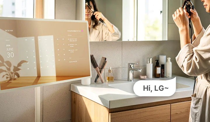 스탠바이미를 보며 머리를 정돈하는 여성의 모습이 보이는 이미지입니다. hi, LG 라고 말하여 음성인식이 됨을 보여줍니다.